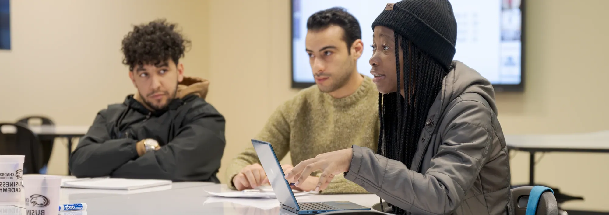 Three students discussing a topic during a graduate 业务 course